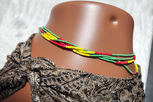 Mannequin wearing a patterned headscarf with colorful waist beads on a white background